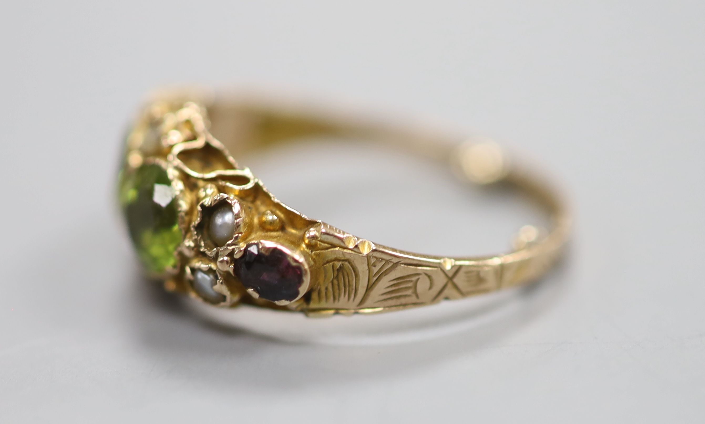 A George V 9ct gold, peridot, seed pearl and garnet set dress ring, in the Suffragette colours, size K, gross 2 grams.